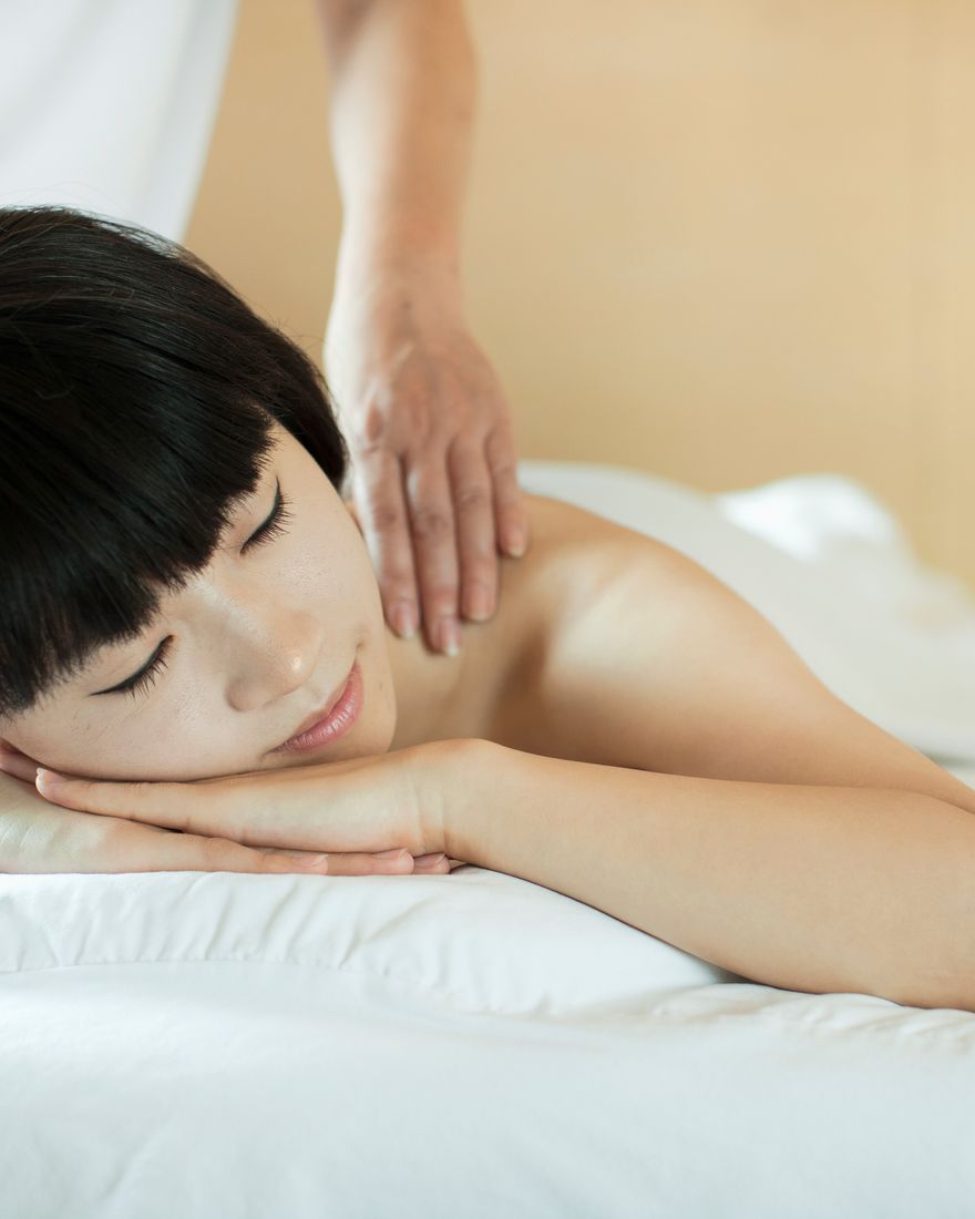顧客趴臥放鬆,師傅按摩背部
